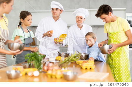 Man and woman cooks, during culinary master class, tell children rules when preparing dough 108479040