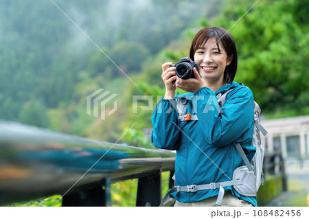 カメラで撮影する女性　ハイキングを楽しむ女性　休日に山でリフレッシュする女性 108482456