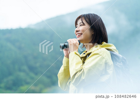 双眼鏡で遠くを見る女性　ハイキングを楽しむ女性　休日に山でリフレッシュする女性 108482646