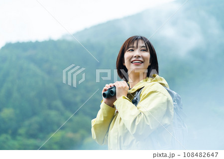 双眼鏡で遠くを見る女性 ハイキングを楽しむ女性 休日に山でリフレッシュする女性 双眼鏡で遠くを見る女性 ハイキングを楽しむ女性 休日に山でリフレッシュする女性 108482647