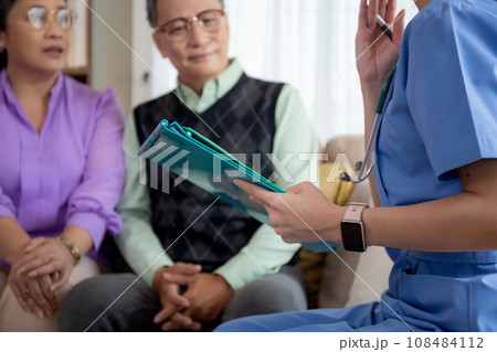 Caregiver sitting on sofa checkup and diagnostic with elderly couple patient about health. 108484112