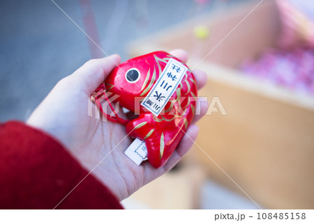 鯛の形のおみくじを引く女の子 108485158