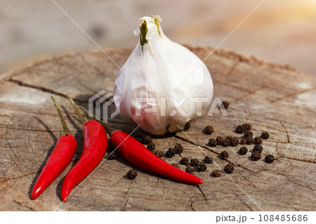 garlic and pepper on a wooden background close-up garlic and pepper on a wooden background close-up 108485686