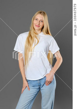 Blonde woman wearing jeans and shirt posing in studio 108487979