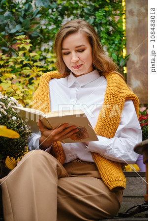 Cute woman sitting on bench and read a book 108488018
