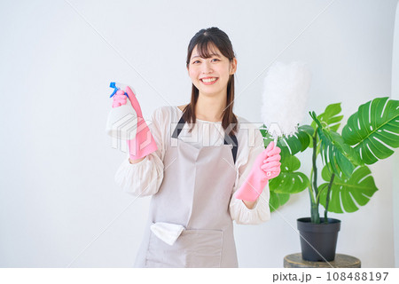 掃除道具を持つ若いエプロン姿の女性 掃除道具を持つ若いエプロン姿の女性 108488197