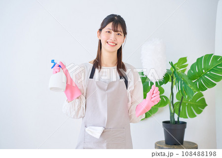 掃除道具を持つ若いエプロン姿の女性 掃除道具を持つ若いエプロン姿の女性 108488198