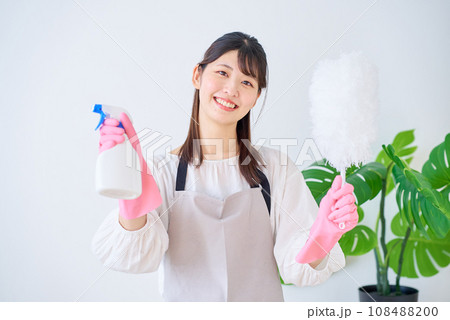 掃除道具を持つ若いエプロン姿の女性 108488200