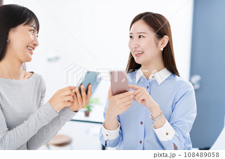 休憩中にスマホを見せ合う女性 休憩中にスマホを見せ合う女性 108489058