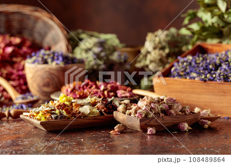 Various dried medicinal plants on a brown background. 108489864