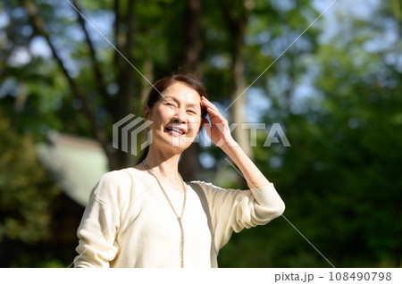 新緑の公園で日光浴するシニア女性 108490798