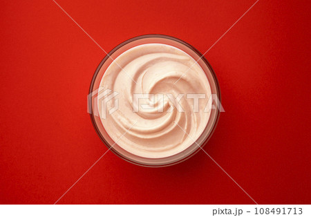 Bowl of strawberry yogurt on red background, top view Bowl of strawberry yogurt on red background, top view 108491713