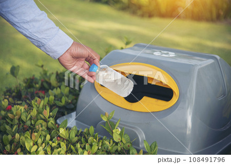 Men hands trow Trash cans for sorting garbage recycle bin waste plastic container collection. Reuse, reduce, recycle sorting process sustainable lifestyle rubbish dustbin plastic box in green garden Men hands trow Trash cans for sorting garbage recycle bin waste plastic container collection. Reuse, reduce, recycle sorting process sustainable lifestyle rubbish dustbin plastic box in green garden 108491796