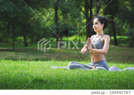 Fit asian woman doing yoga meditation in park fitness and heakthy outdoor concept Fit asian woman doing yoga meditation in park fitness and heakthy outdoor concept 108492767