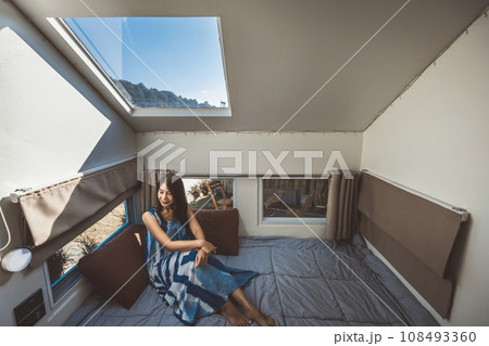 Travel woman with dress relax inside a camper car recreational vehicle Travel woman with dress relax inside a camper car recreational vehicle 108493360
