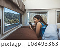 Travel woman with mobile phone relax inside a camper car recreational vehicle 108493363