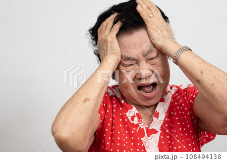 A senior woman who has a severe headache suffers from a stroke ,brain disease,patient holding head with her hand,suffering from senile dementia,memory disorders, confused old elderly with Alzheimer 108494138