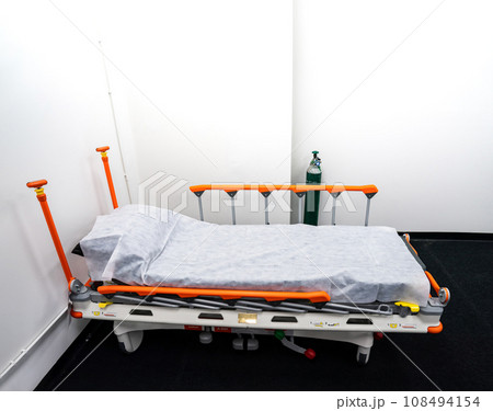 Camp bed with orange bed rails for side effect of Covid-19 vaccinated patient, it is able to be temporarily moved everywhere. This place has an equipment disinfection. 108494154