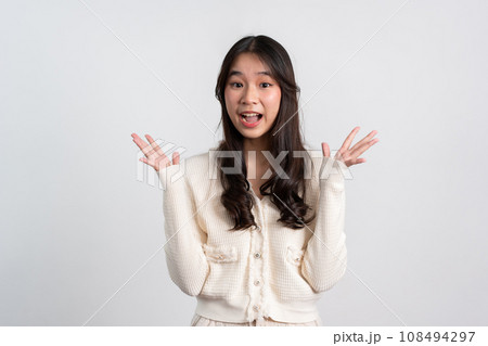 Happy cheerful young Asian girl with long light hair smiling brightly feeling happy with a positive expression, joyful surprise funky, Female in black with a big smile isolated on white background. 108494297