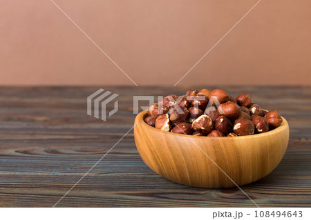 Wooden bowl full of hazelnuts on table background. Healthy eating concept. Super foods Wooden bowl full of hazelnuts on table background. Healthy eating concept. Super foods 108494643