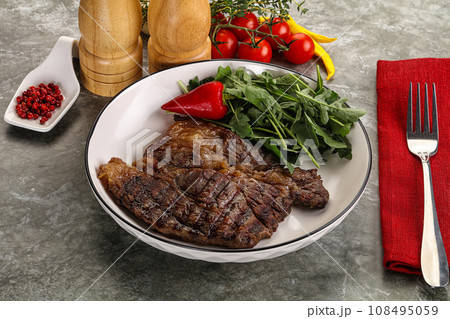 Grilled chuck roll steak with arugula 108495059