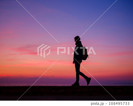 Woman tourist against colorful sunset sky. Travel, tourism concept. Active lifestyle. Woman tourist against colorful sunset sky. Travel, tourism concept. Active lifestyle. 108495733