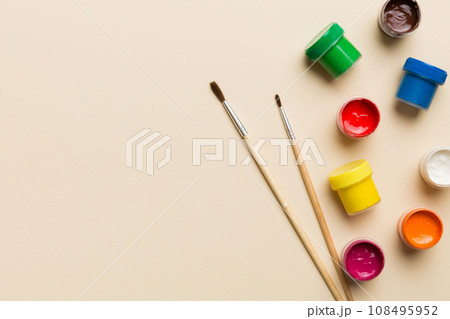 art palette with paint and brushes, close up. Top view with empty space. workplace for creativity. home teaching concept drawing 108495952