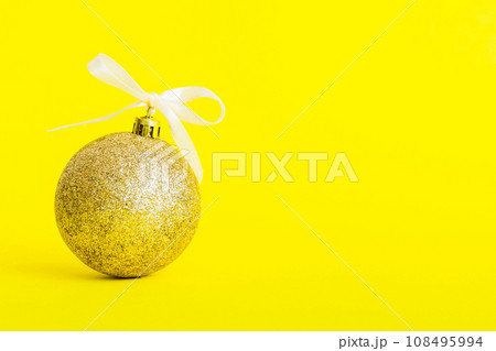 Christmas ball on colored background. decoration bauble with ribbon bow with copy space Christmas ball on colored background. decoration bauble with ribbon bow with copy space 108495994