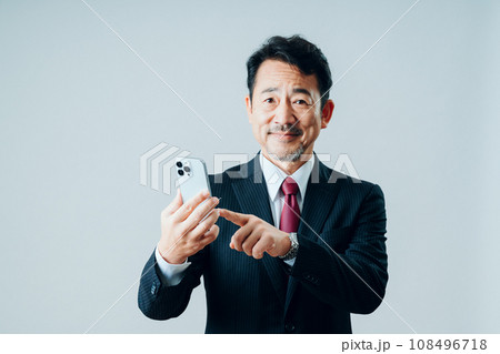 スマートフォンを操作するシニア男性。（グレーバック） 108496718