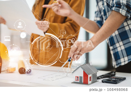Two colleagues discussing data working and tablet, laptop with on on architectural project at construction site at desk in office. Two colleagues discussing data working and tablet, laptop with on on architectural project at construction site at desk in office. 108498068