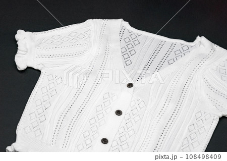 close up to flat White knitwear tshirt shape on black background with studio light. close up to flat White knitwear tshirt shape on black background with studio light. 108498409