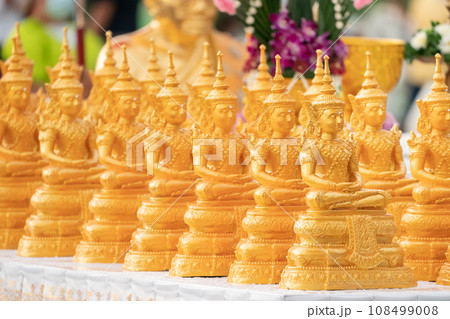 Golden Buddha statues placed on the white table, which were wet by rain felled and prepared for a religion ceremony event. Golden Buddha statues placed on the white table, which were wet by rain felled and prepared for a religion ceremony event. 108499008