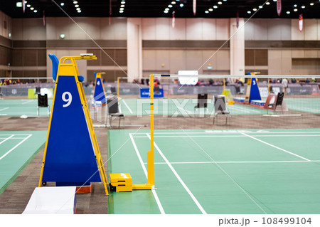 Blue chair of badminton referee with yellow colors near badminton net with blurred background in sport indoor stadium. 108499104