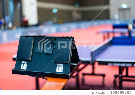 A tennis table black scoreboard is placed next to the table tennis table for referee count the score, which acts as a blurred background of pingpong tournament. 108499206