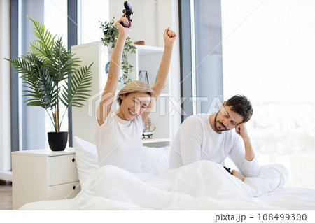 Caucasian couple in love have fun competing in laptop game using joysticks 108499300