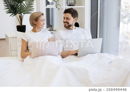 Amorous people spending time together using laptop in bed Amorous people spending time together using laptop in bed 108499446