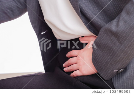 下腹部が痛そうに手を当てている女性 108499602