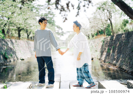 手を繋いで川を渡るカップル 108500974