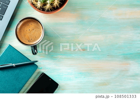 Desk, top view on a wooden background. Coffee, notebook, phone, plant 108501333