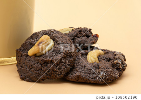 Dark Chocolate Cookies with raisin inside it on the light orange colour background. Dark Chocolate Cookies with raisin inside it on the light orange colour background. 108502190