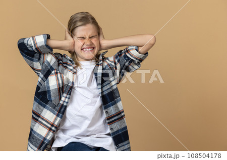 Teen girl in checkered shirt looking stressed and unhappy 108504178