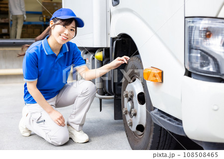 トラックの始業点検を行う若い女性ドライバー 108508465