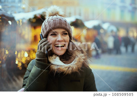 smiling woman at christmas fair in city talking on phone 108509505