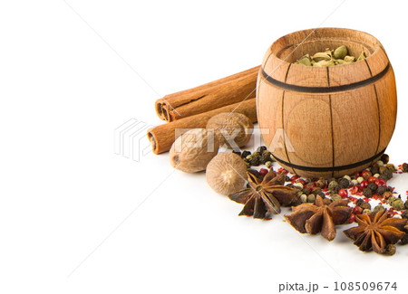 Cardamom in wooden bowl and spices set isolated on white . Free space for text. Cardamom in wooden bowl and spices set isolated on white . Free space for text. 108509674