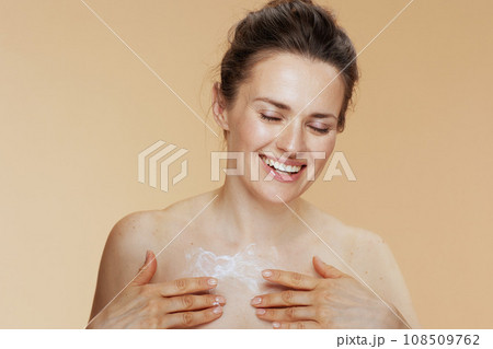 happy woman rubbing body cream happy woman rubbing body cream 108509762
