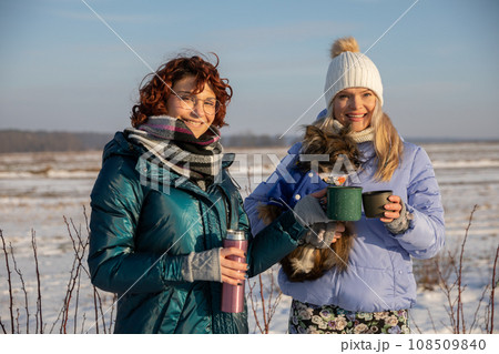 Drinking tea together from a thermos in the open air. 108509840