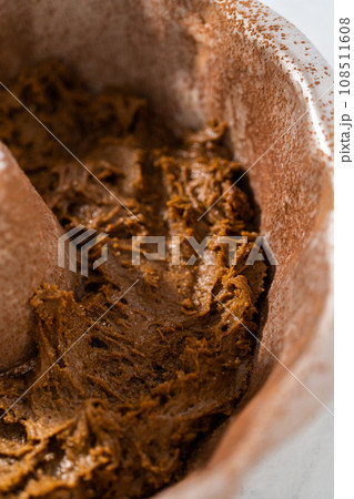 Filling metal bundt cake pan with cake butter to bake gingerbread bundt cake with caramel filling. 108511608