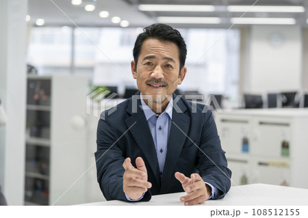 カメラ目線で話す50代のビジネスマン 108512155