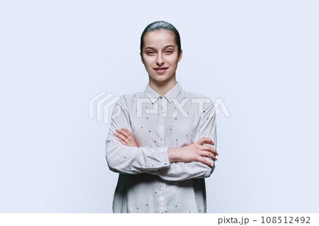 Portrait of teenage girl with crossed arms on white background 108512492