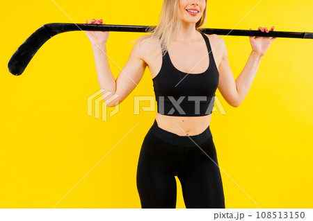 Ice hockey fan female in sports wear with hockey stick in studio Ice hockey fan female in sports wear with hockey stick in studio 108513150